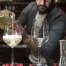 Ein Barkeeper mixt Cocktails in einer Bar, während er sprudelndes Getränk in ein Glas gießt, ideal für einen geselligen Abend.