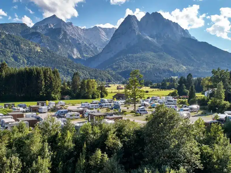 Campingplatz in den Alpen, umgeben von Bergen und Wäldern, ideal für Familienurlaube und Naturerlebnisse in der Region.